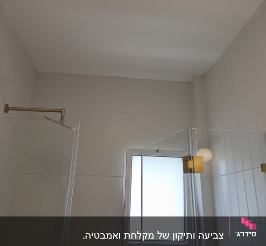 חדר אמבטיה עם מקלחון וחלון קטן